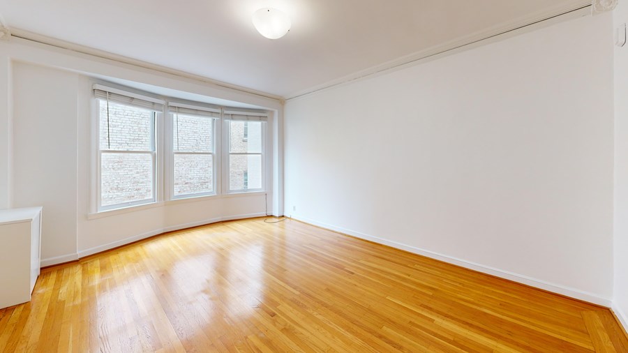A room with wooden flooring and a window.
